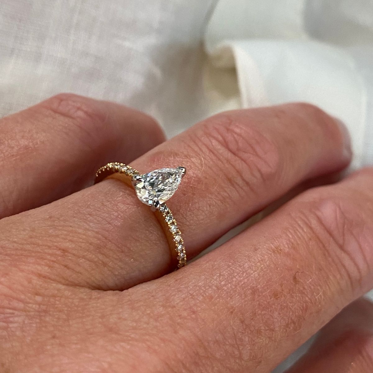 Pear shape diamond ring with diamonds on band