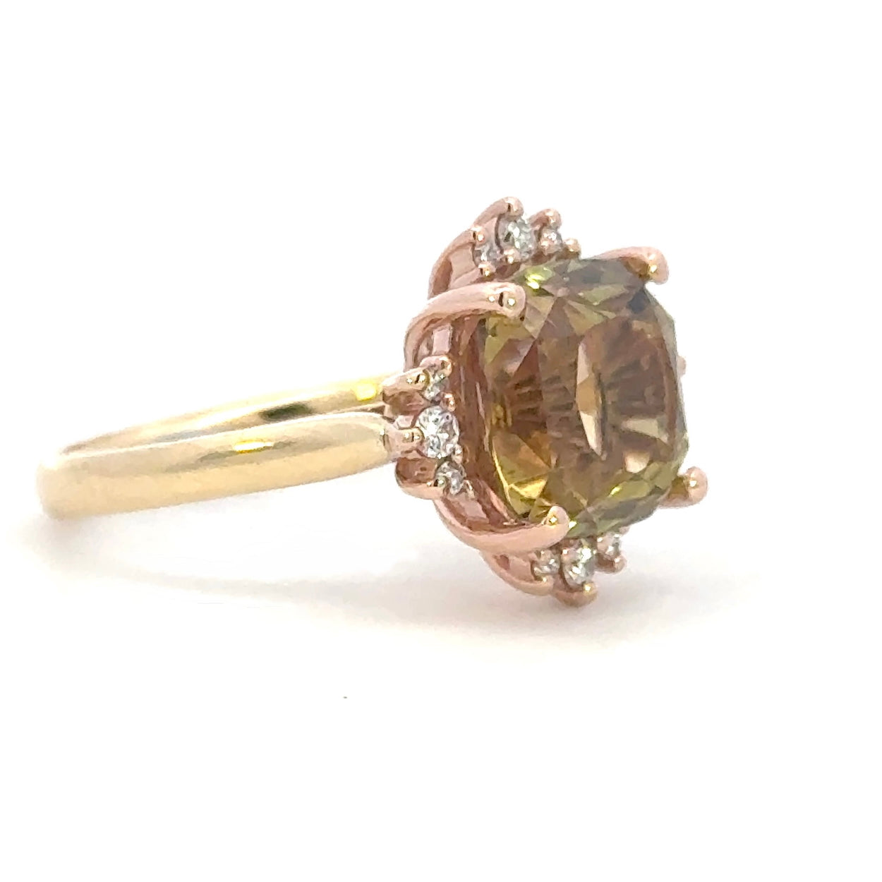 Rose and yellow gold ring with a large brown gold tourmaline gemstone and smaller diamonds on a white background angle view