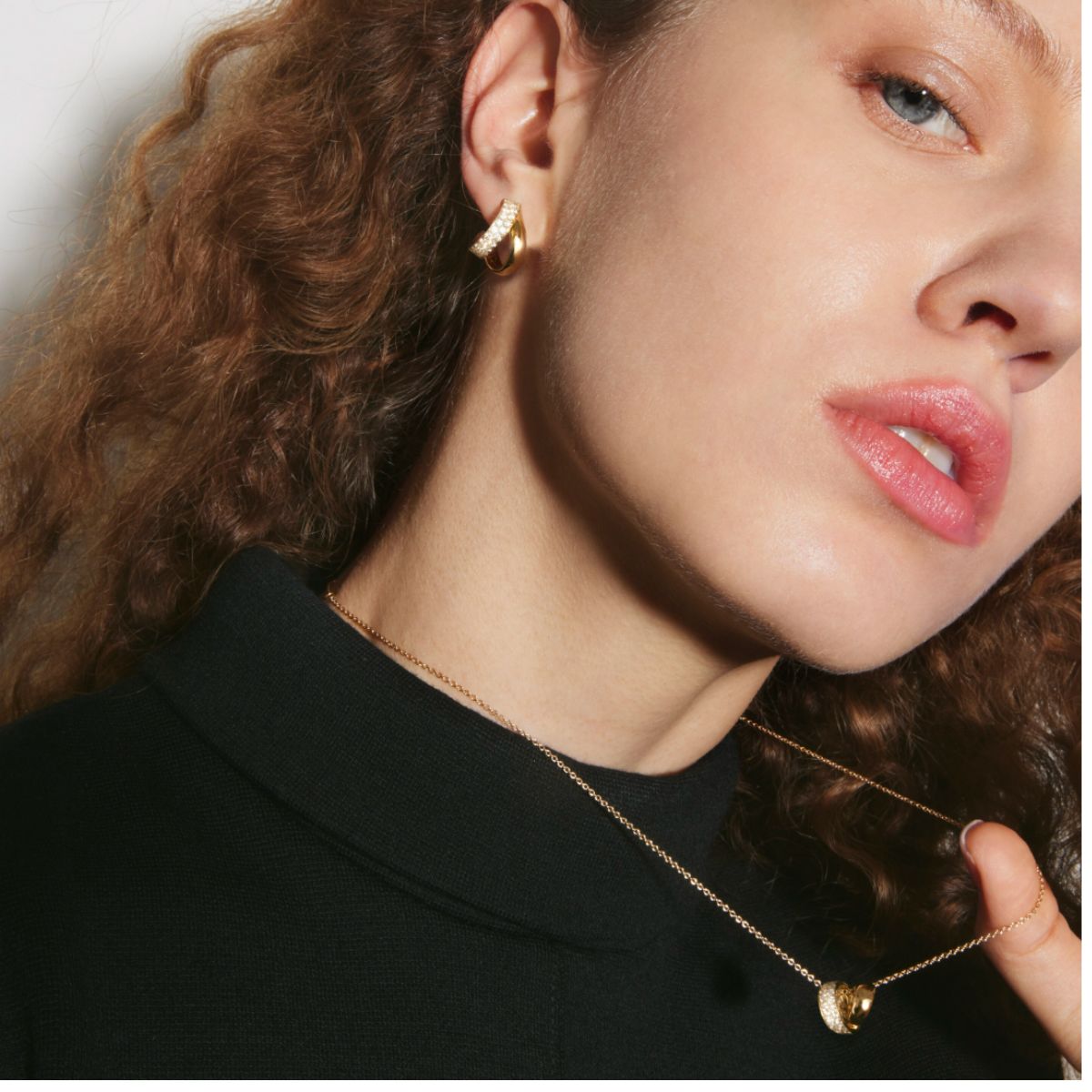 Close-up of a woman wearing gold multi wear pendant inside/ out collection