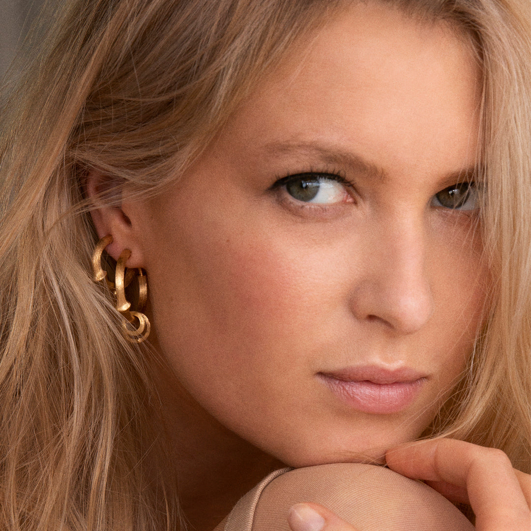 Close up of woman wearing Ole Lynggaard Nature Hoop Earrings
